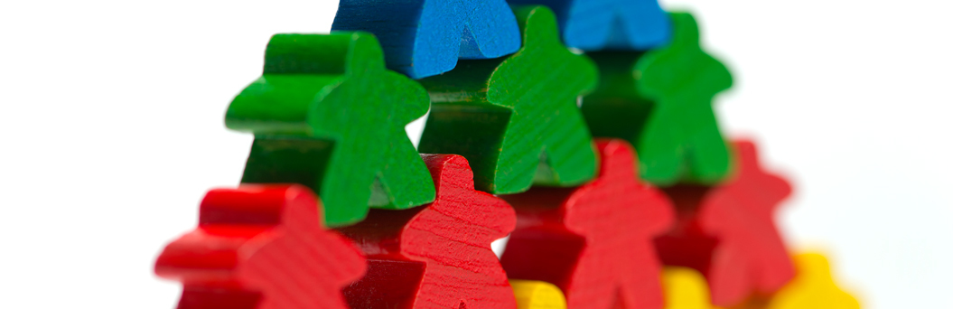 Spielfiguren in vier unterscheidlichen Farben sind zu einem Dreieck übereinander gestapelt, im Bild ein Ausschnitt des Dreiecks