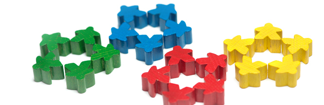 Spielfiguren in vier unterschiedlichen Farben zu vier Kreisen gelegt